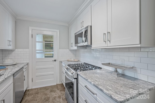 kitchen featuring stainless steel appliances, backsplash, crown molding, light stone countertops, and white cabinets