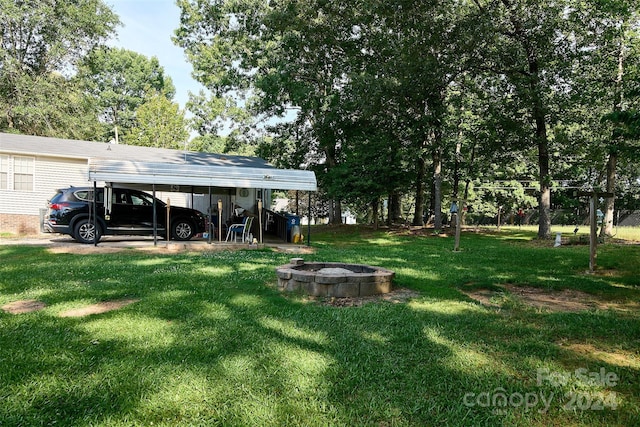 view of yard with an outdoor fire pit and a carport