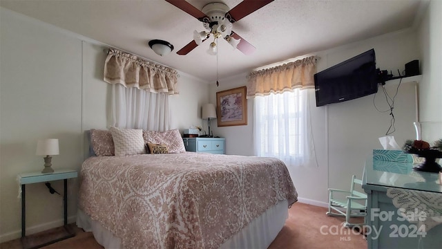 carpeted bedroom featuring ceiling fan and crown molding