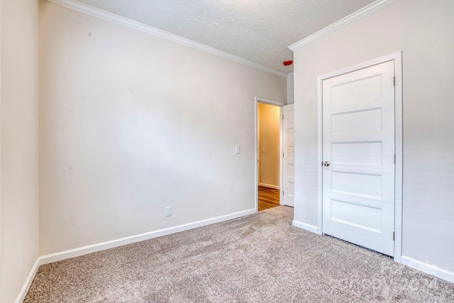 unfurnished bedroom with a textured ceiling, crown molding, and light colored carpet