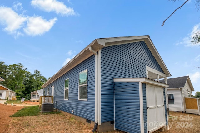 view of property exterior with a shed and cooling unit