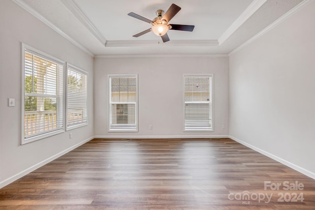 spare room featuring hardwood / wood-style flooring, ornamental molding, and a raised ceiling