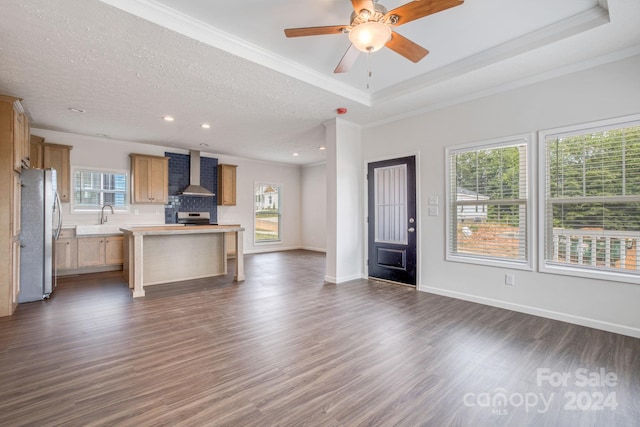 unfurnished living room featuring plenty of natural light, dark hardwood / wood-style flooring, ornamental molding, and a textured ceiling