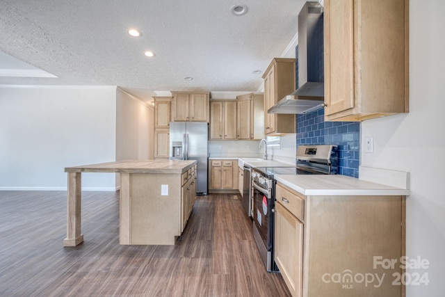 kitchen featuring a textured ceiling, light brown cabinetry, stainless steel appliances, and wall chimney exhaust hood