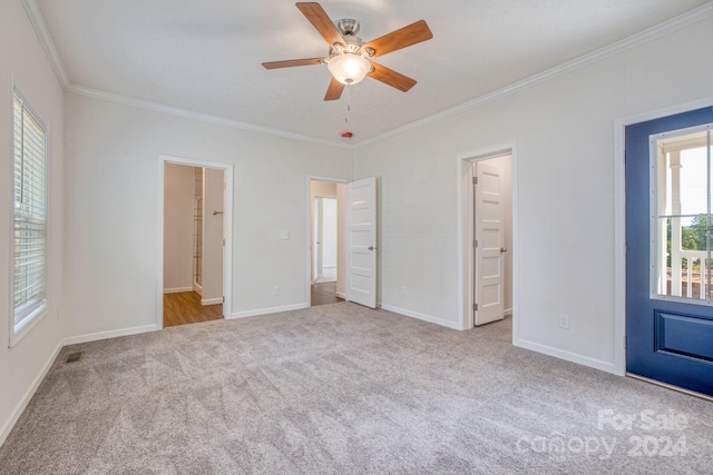 unfurnished bedroom with ceiling fan, ensuite bath, light carpet, and ornamental molding