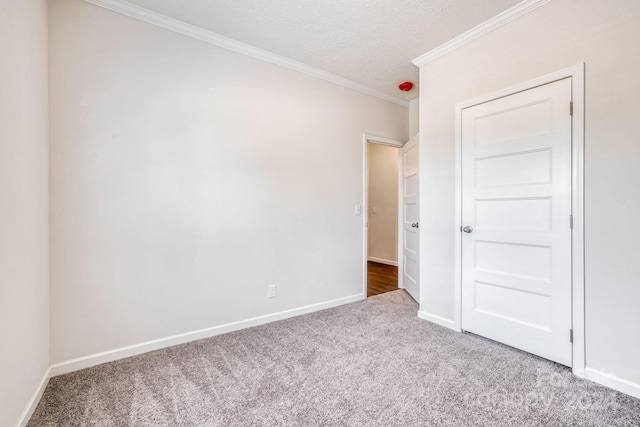 unfurnished bedroom featuring crown molding, a textured ceiling, and carpet flooring