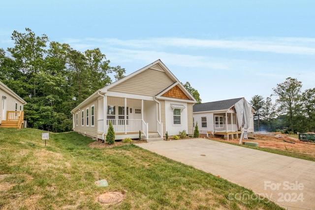 view of front of house featuring covered porch and a front yard