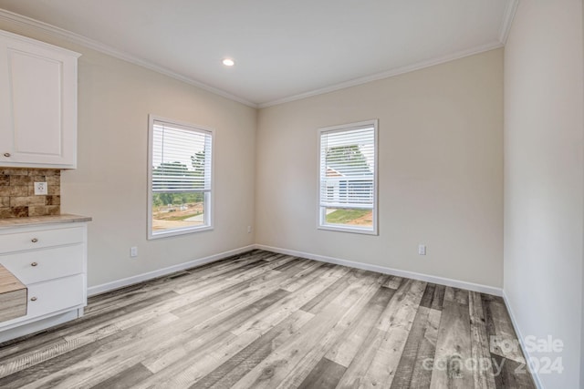 unfurnished dining area with crown molding and light hardwood / wood-style flooring