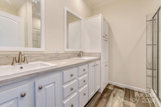 bathroom with crown molding, vanity, wood-type flooring, and a shower with door