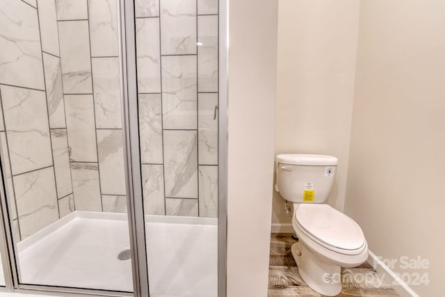 bathroom featuring walk in shower and toilet