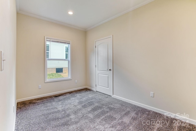 carpeted spare room featuring crown molding