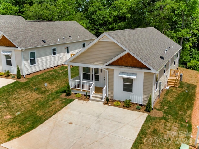 view of front of house with a front yard and a porch