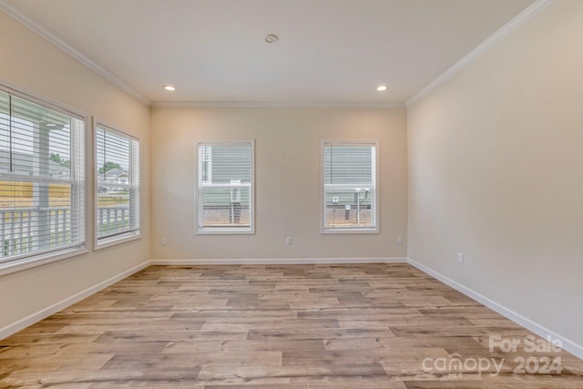 empty room featuring light hardwood / wood-style flooring and ornamental molding