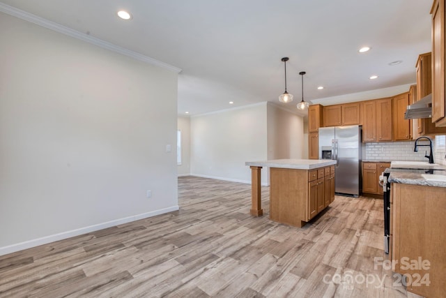 kitchen featuring backsplash, a kitchen island, stainless steel appliances, crown molding, and light hardwood / wood-style flooring