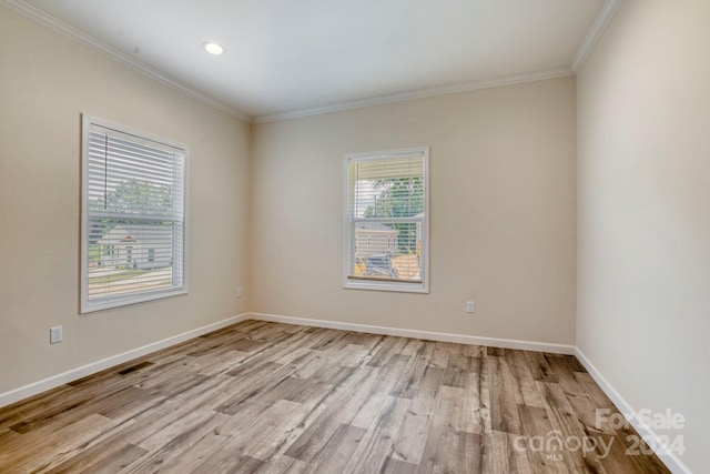 empty room with light hardwood / wood-style floors and ornamental molding