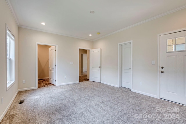 unfurnished bedroom with light colored carpet, connected bathroom, and crown molding