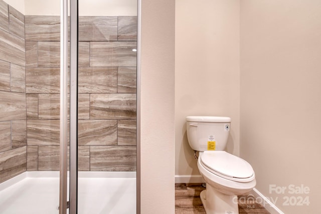 bathroom with walk in shower, hardwood / wood-style flooring, and toilet