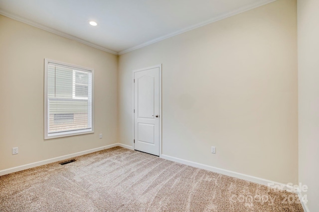 empty room with ornamental molding and carpet