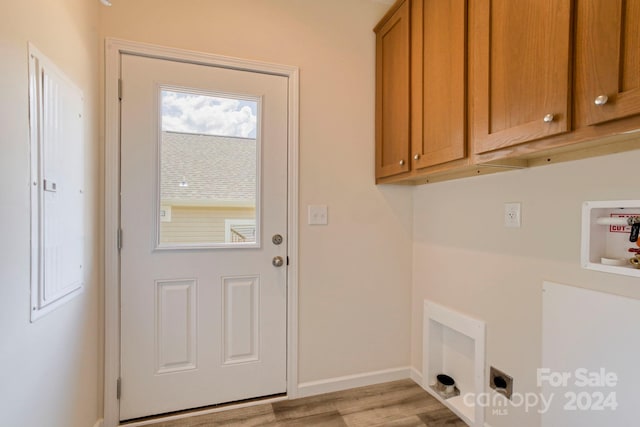 laundry room with light wood-type flooring, hookup for a washing machine, electric dryer hookup, and cabinets