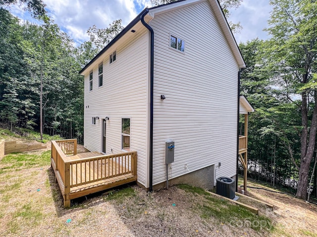 view of property exterior with a wooden deck and central AC