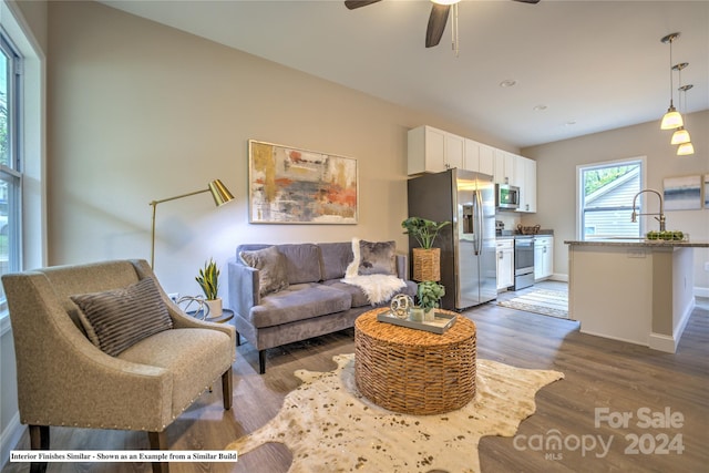 living room with dark hardwood / wood-style floors, ceiling fan, and sink