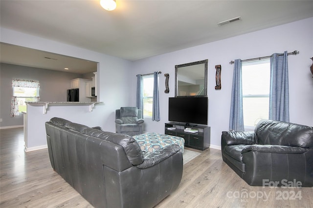 living room with a wealth of natural light and light hardwood / wood-style flooring