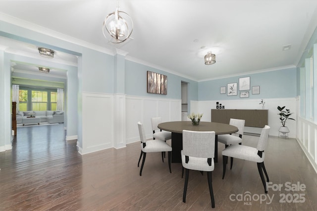 dining room featuring dark hardwood / wood-style flooring, a chandelier, and crown molding