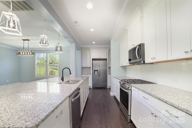 kitchen featuring stainless steel appliances, light stone countertops, pendant lighting, sink, and white cabinetry