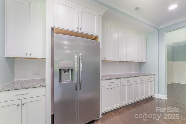 kitchen with white cabinets, light stone counters, backsplash, and stainless steel fridge with ice dispenser