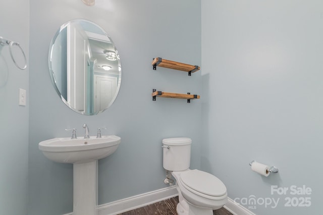 bathroom featuring toilet, sink, and hardwood / wood-style flooring