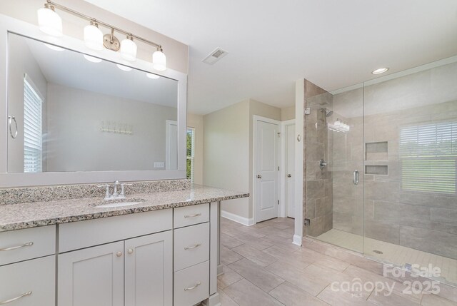 bathroom featuring tile patterned floors, walk in shower, and vanity