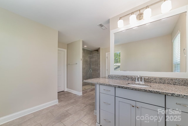 bathroom with a healthy amount of sunlight, an enclosed shower, and vanity