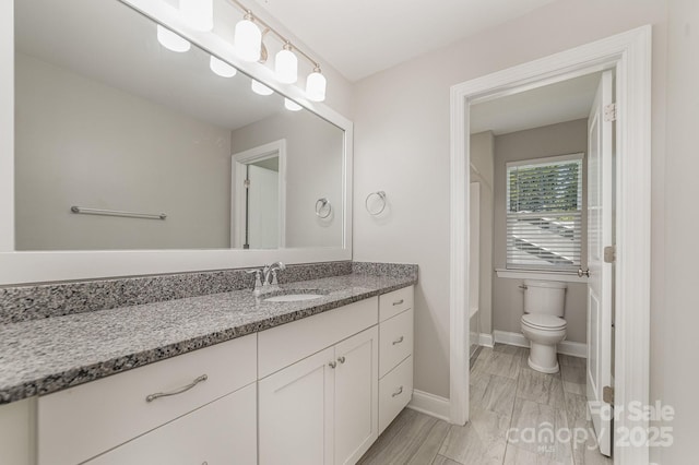 bathroom featuring a bath, vanity, and toilet