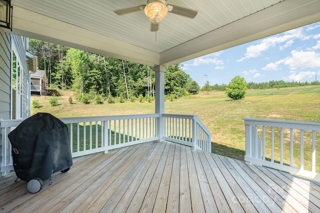 wooden deck with grilling area, ceiling fan, and a yard