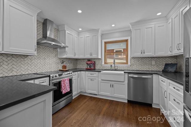 kitchen with sink, white cabinets, tasteful backsplash, wall chimney range hood, and appliances with stainless steel finishes