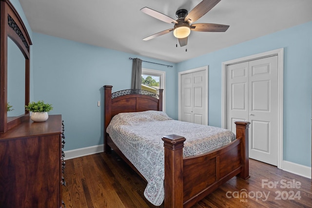 bedroom featuring dark wood-type flooring, two closets, and ceiling fan