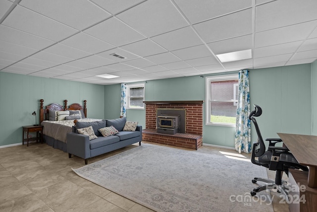 bedroom with a paneled ceiling and a wood stove