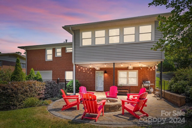 back house at dusk featuring a fire pit and a patio area