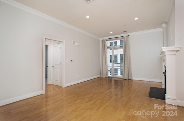 unfurnished living room featuring light wood-type flooring and ornamental molding