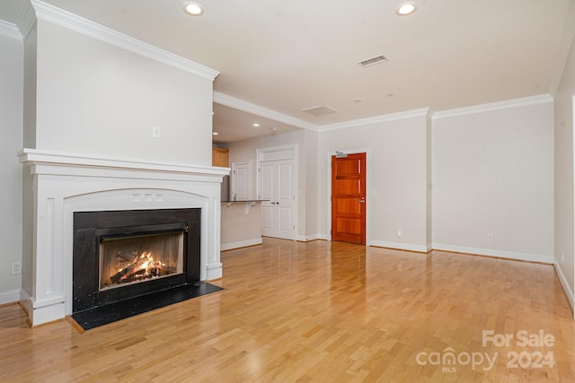 unfurnished living room featuring light wood-type flooring and ornamental molding