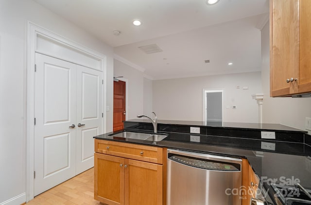 kitchen with light wood-type flooring, dark stone counters, ornamental molding, stainless steel dishwasher, and sink