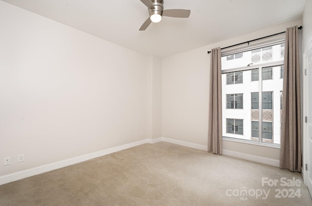 carpeted spare room featuring ceiling fan