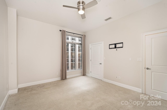 spare room featuring ceiling fan and light colored carpet