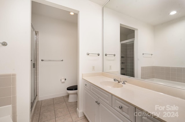 bathroom with an enclosed shower, vanity, tile patterned flooring, and toilet