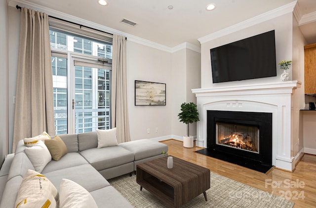 living room featuring a wealth of natural light, light hardwood / wood-style floors, and ornamental molding