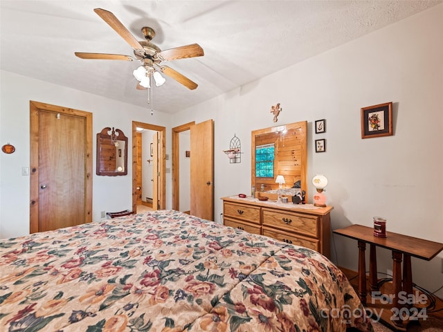 bedroom with ceiling fan and a textured ceiling