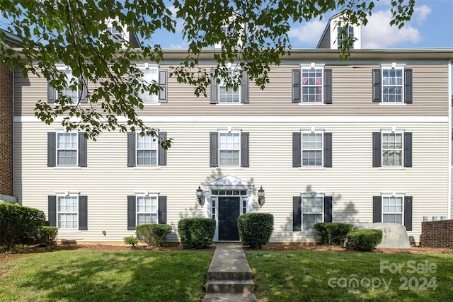 colonial-style house featuring a front yard