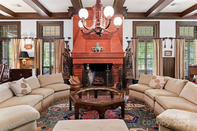 living room featuring a brick fireplace, beam ceiling, a chandelier, and coffered ceiling