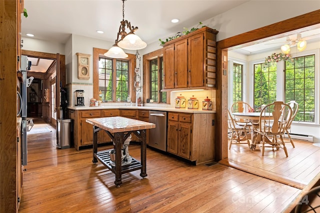 kitchen with hanging light fixtures, dishwasher, tasteful backsplash, and light hardwood / wood-style floors