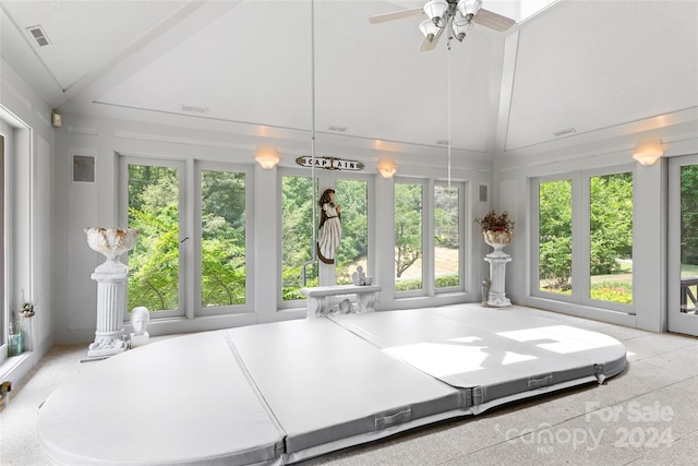 unfurnished sunroom with ceiling fan and vaulted ceiling with beams